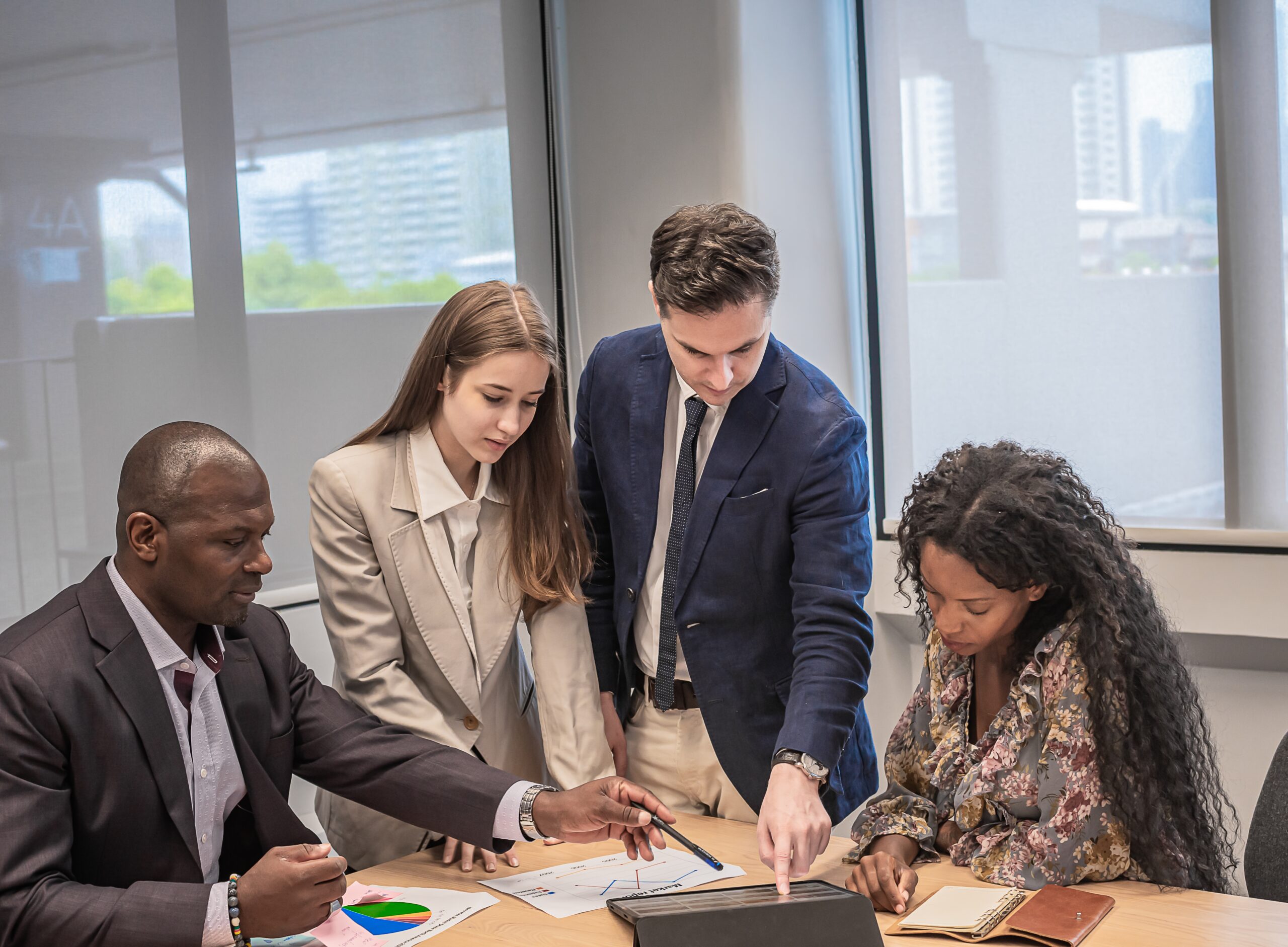 Team meeting using a tablet to plan marketing strategies for a reseller business in Africa.